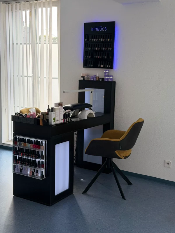 Maniküre-Tisch mit gelbem Sessel, Nagellackregalen und großer Fensterfront